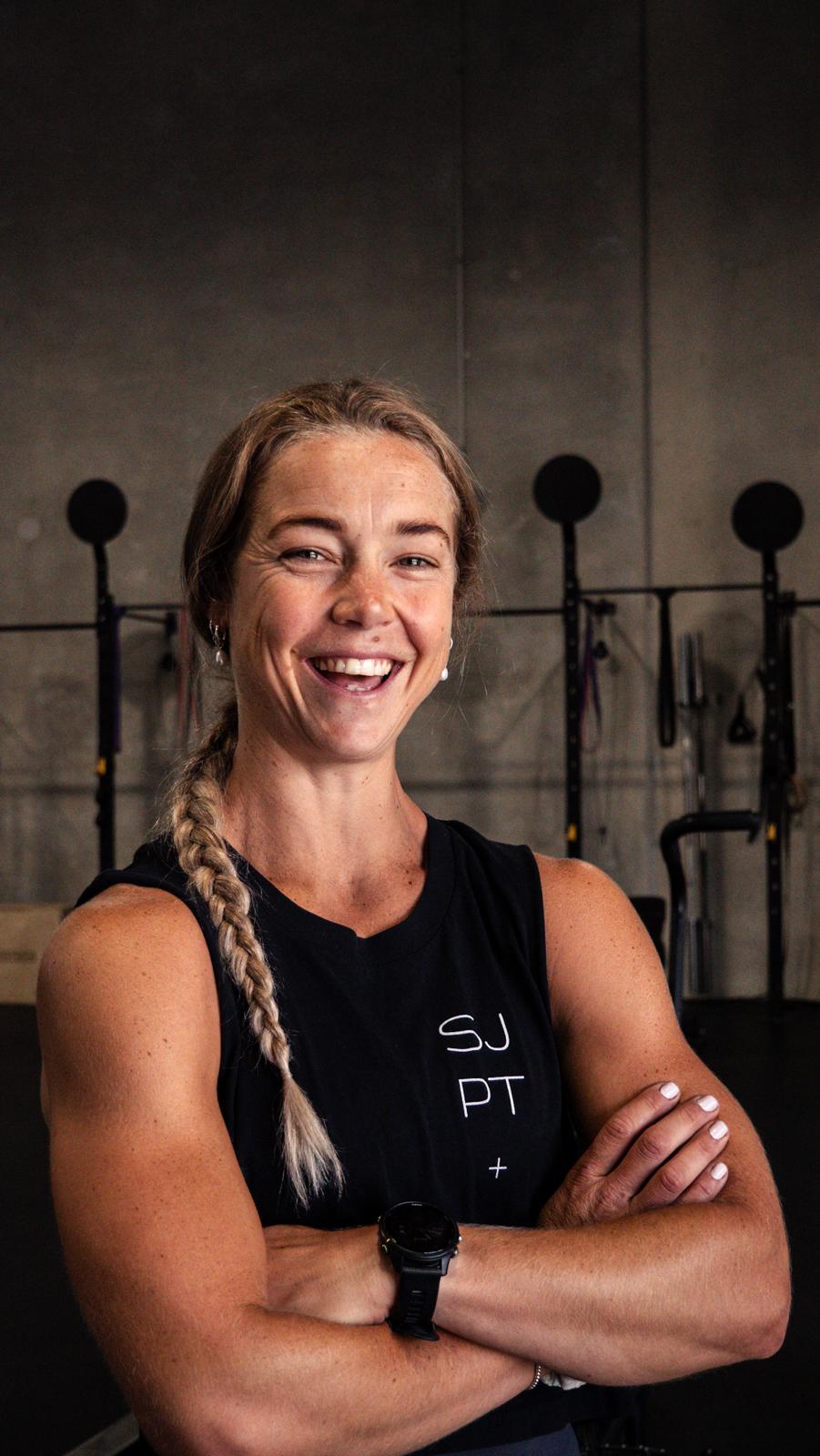 Somer Jones, health and fitness coach, smiling at the camera in a gym
